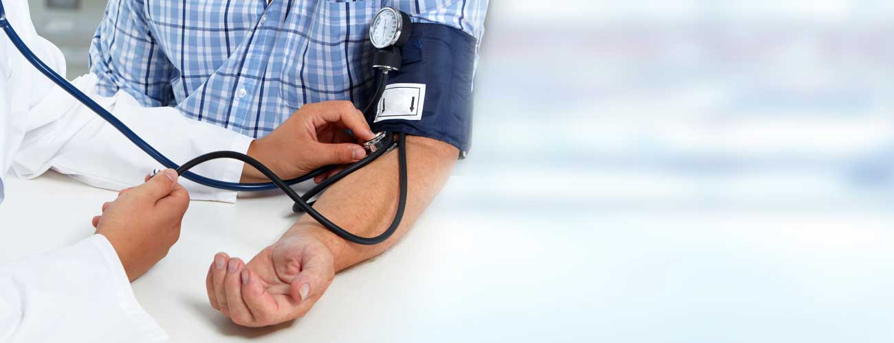 Man getting blood pressure taken by doctor