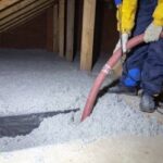 a man installing TAP insulation into an attic